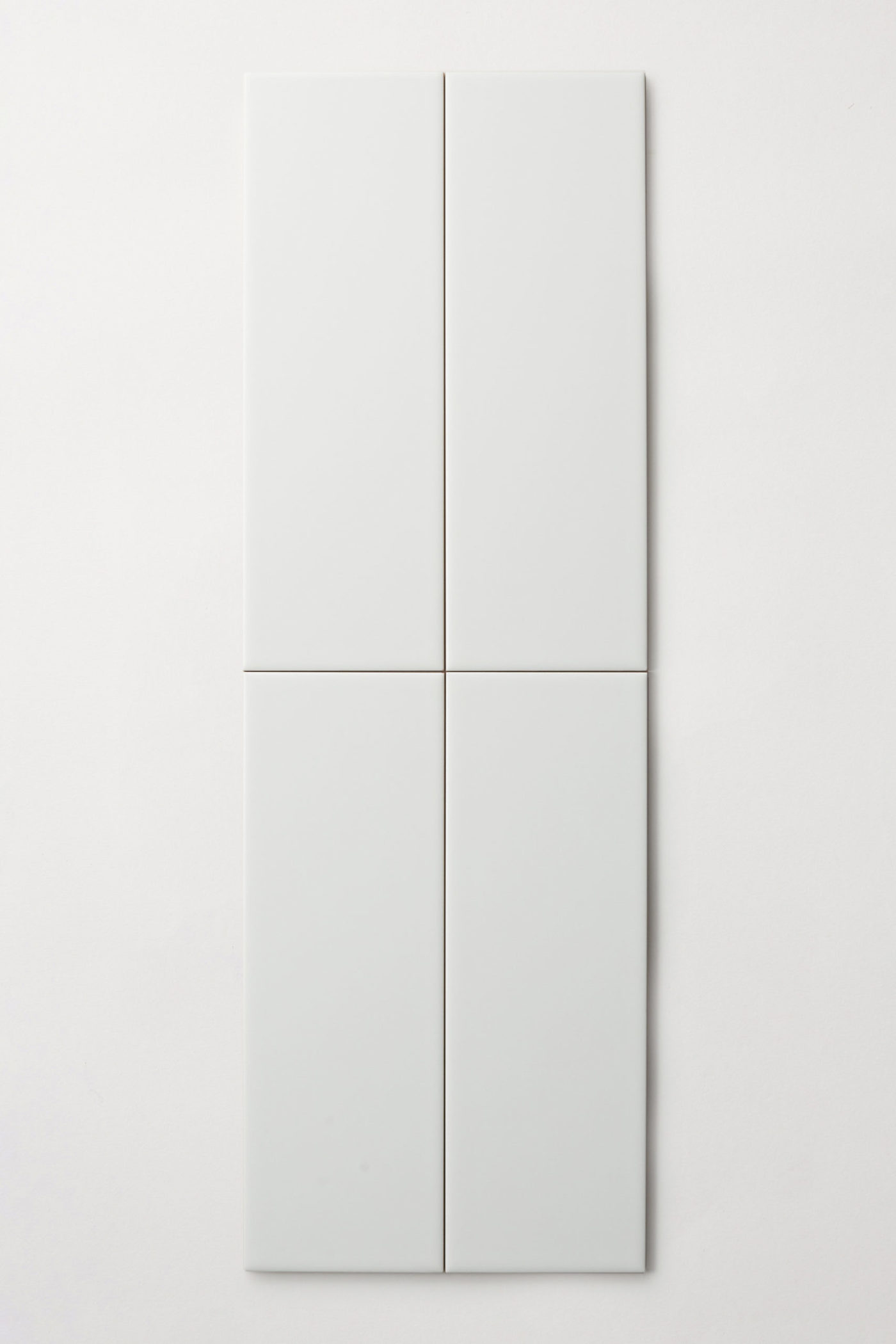 four rectangular white tiles on a white surface.