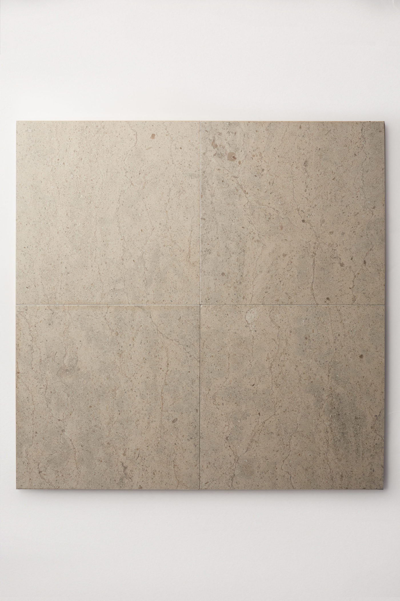 four medium-grey beige colored square limestone tiles laid together making one large square