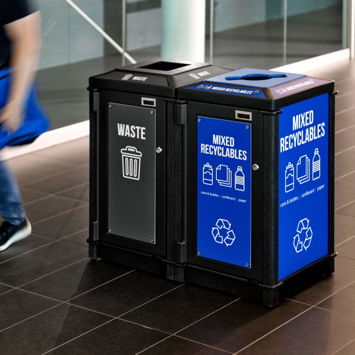 black recycled plastic waste and recycling container with bold signs and labels inside a fitness center