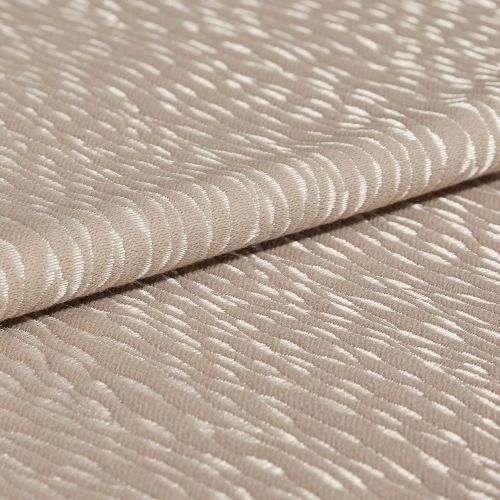 Beige jacquard fabric with glossy, raised crescent pattern; folded once across the frame, overlapping edges; close-up studio view with soft, diffuse lighting emphasizing the textured sheen.