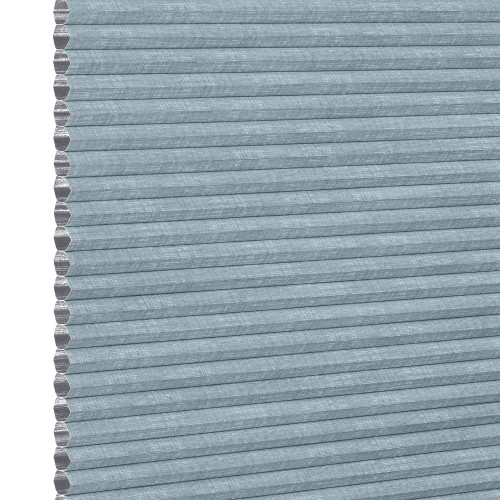 Light-blue textured cellular (honeycomb) pleated shade, tightly closed showing hexagonal cell edges at left; blocking light and insulating a window within a softly lit interior, neutral background.