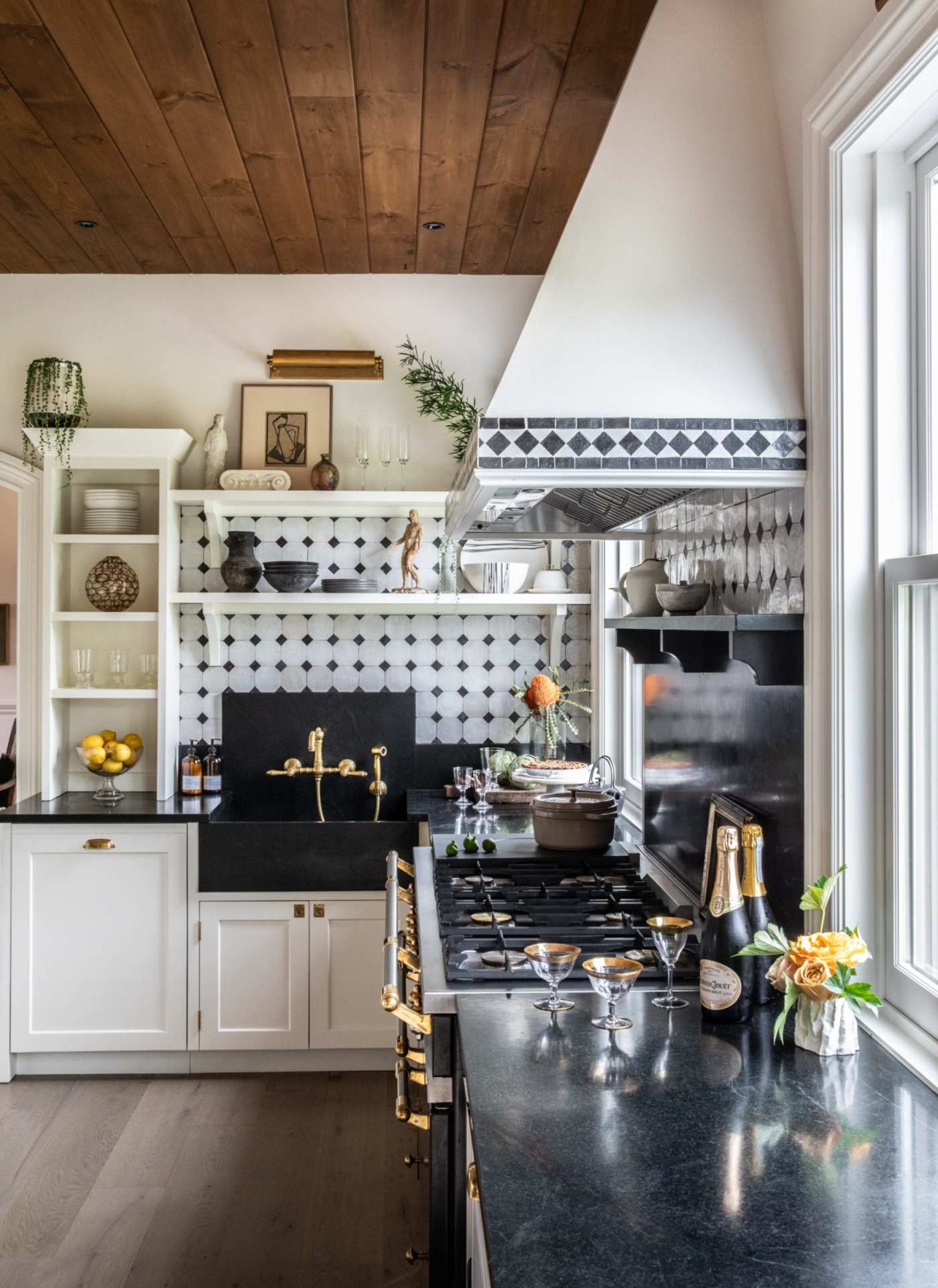 a kitchen with a wooden ceiling and blue and white tiled backsplash.