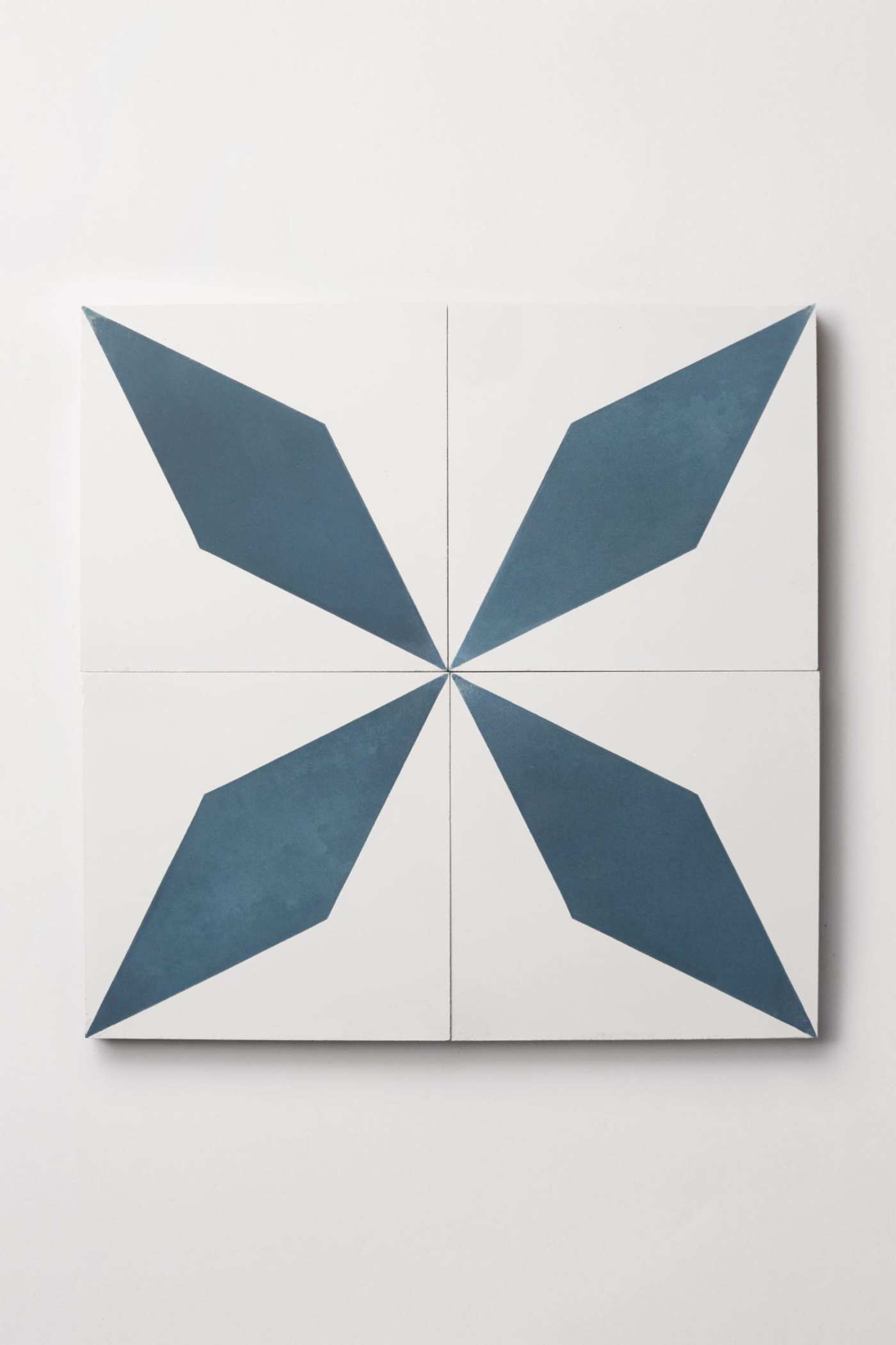 four blue and white tiles on a white surface.