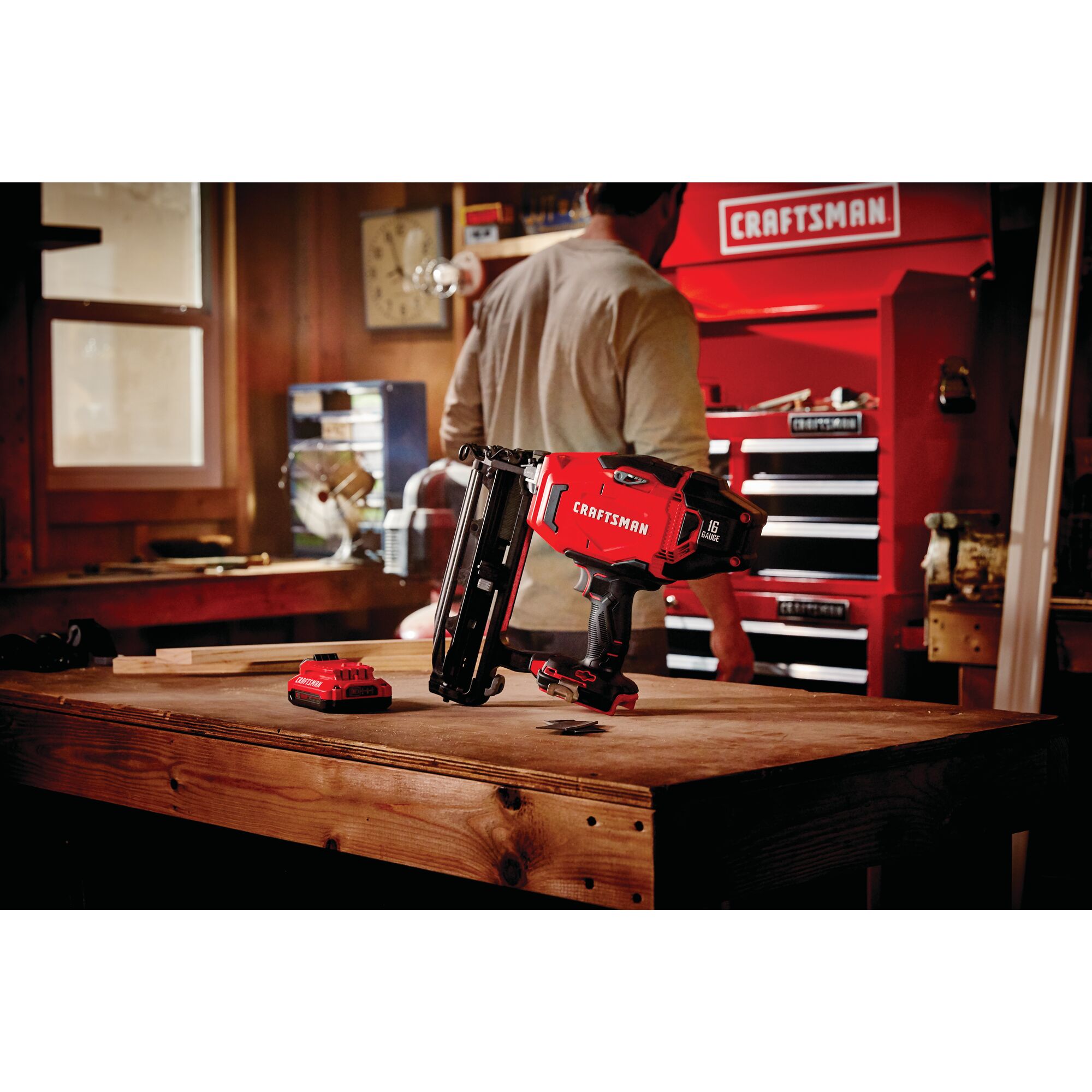 20 volt cordless 16 gauge finish nailer kit placed on a wooden table at a work station.