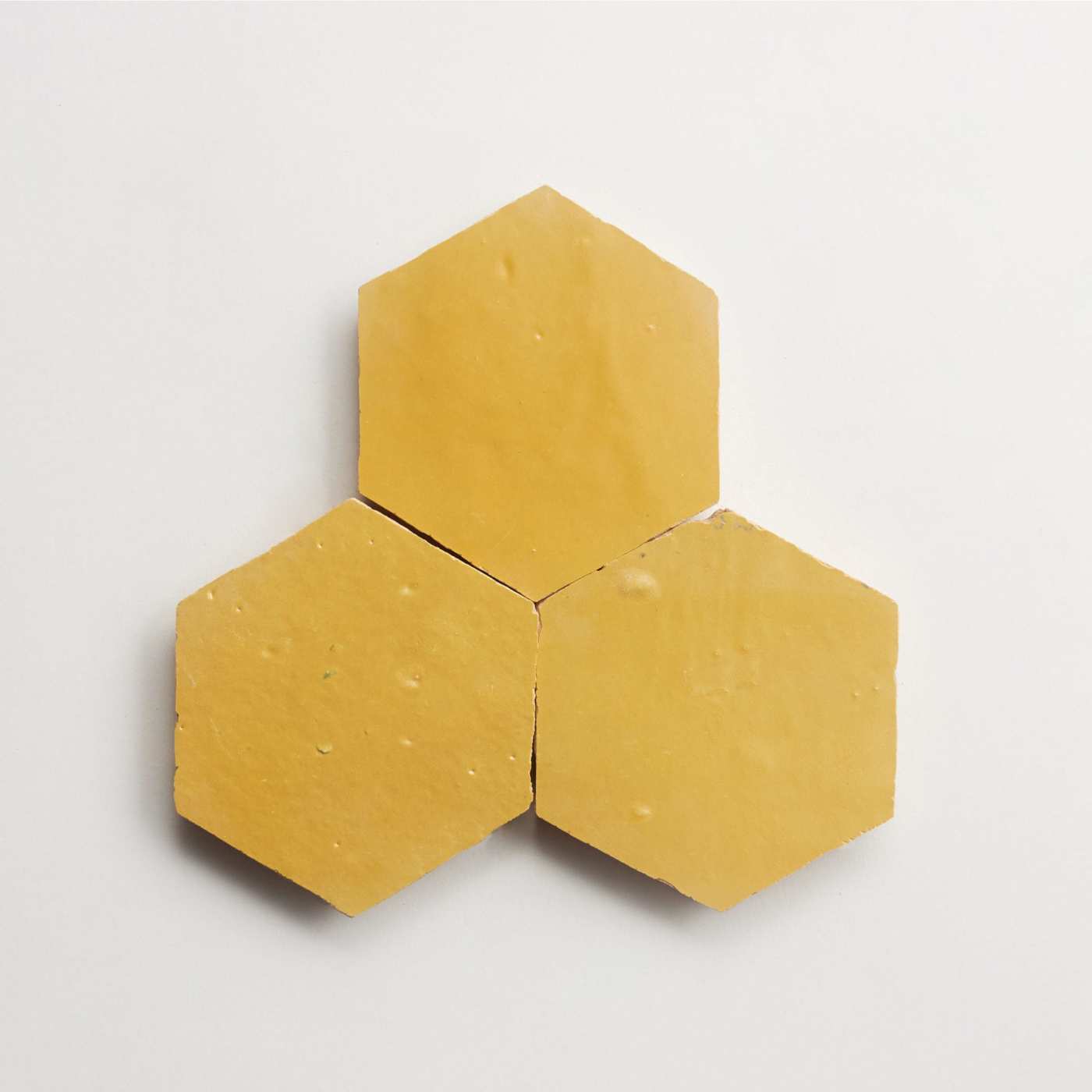 three yellow hexagon tiles on a white surface.