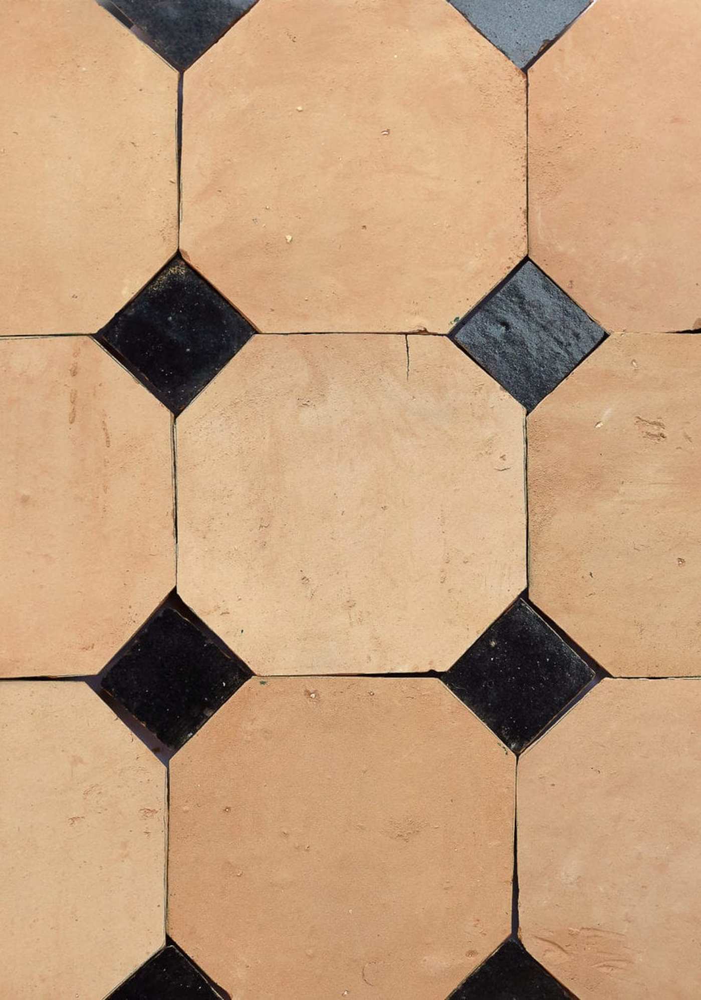 black and terracotta tiles arranged in a pattern.