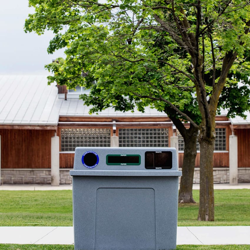 triple stream recycling and waste station with grey plastic body and color coded openings at a city park