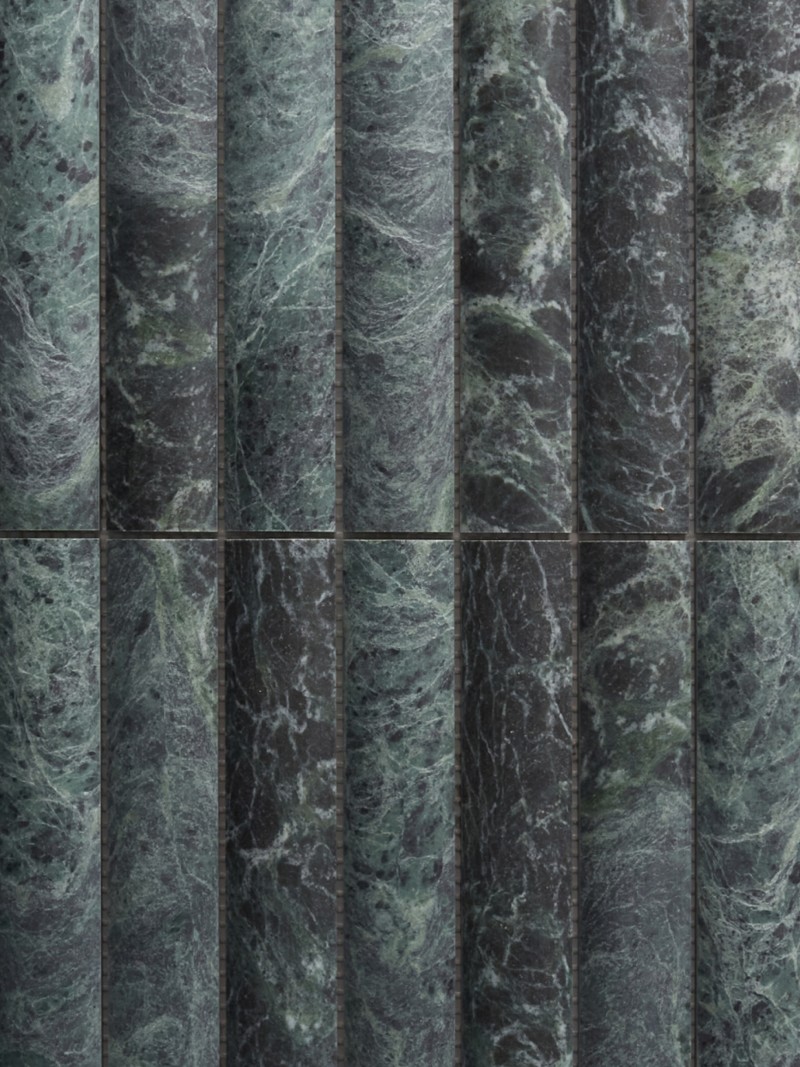 a row of green marble tiles on a wall.