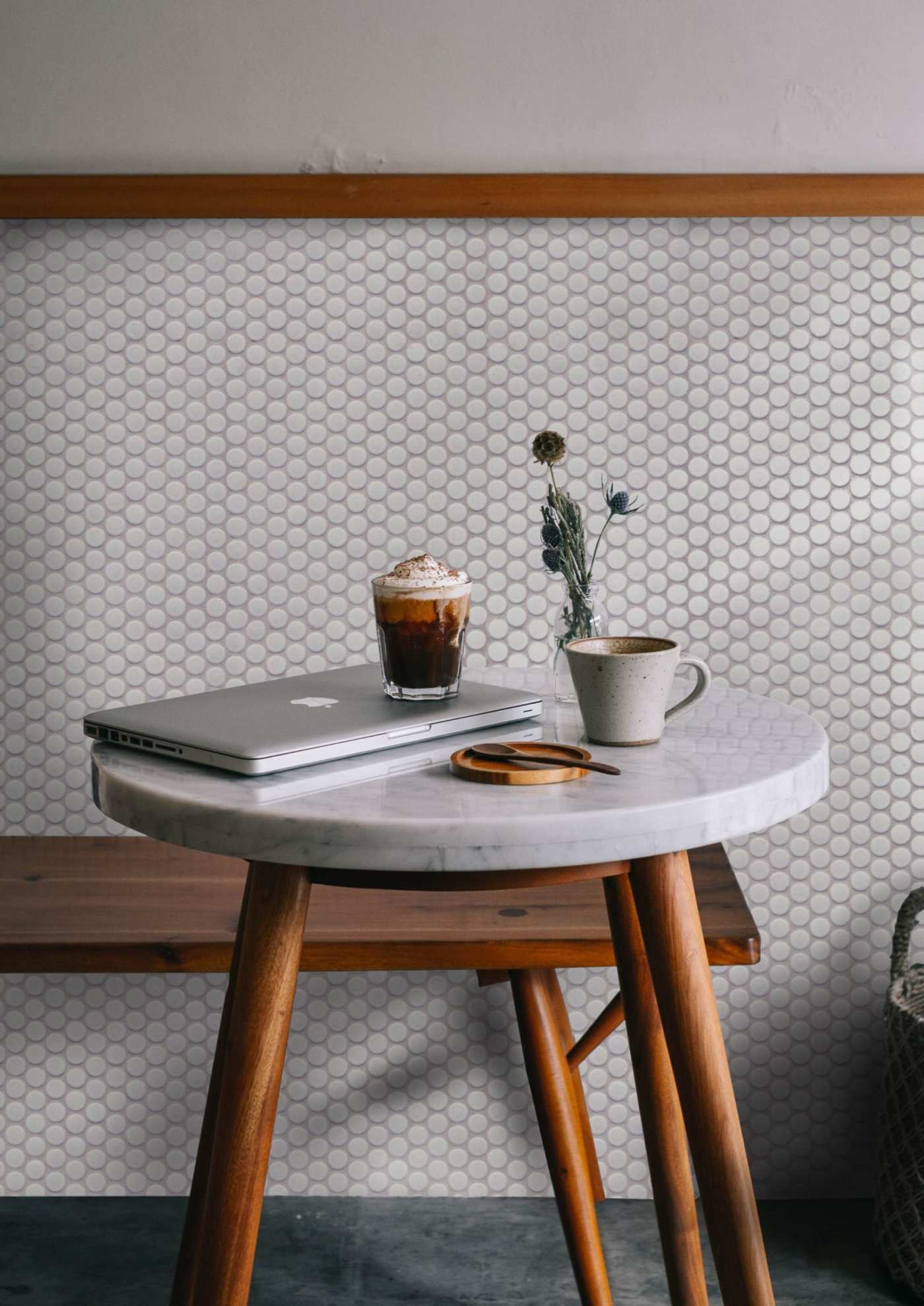 a coffee table in front of a white tiled wall.