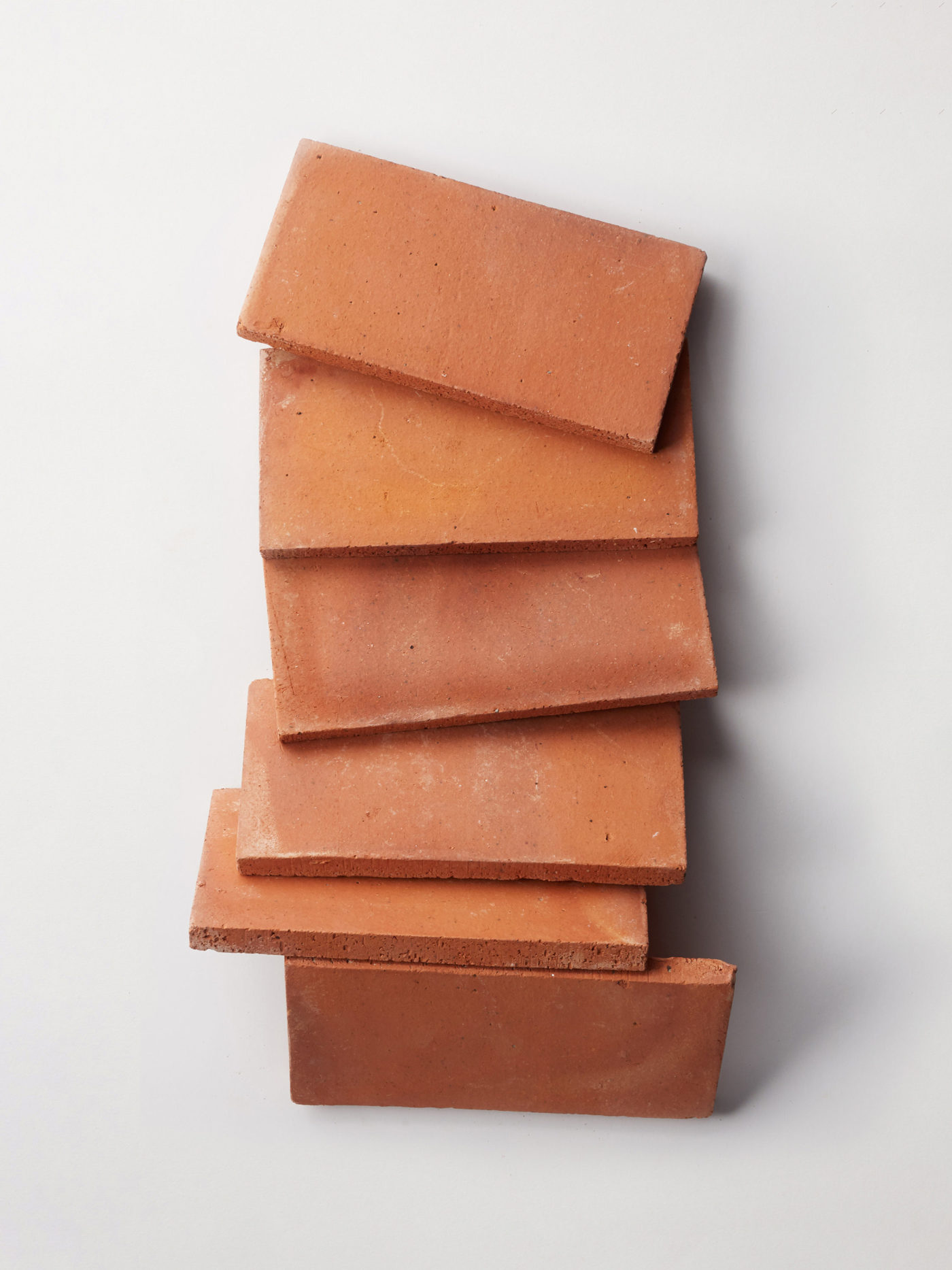 a stack of red terracotta tiles on a white background.