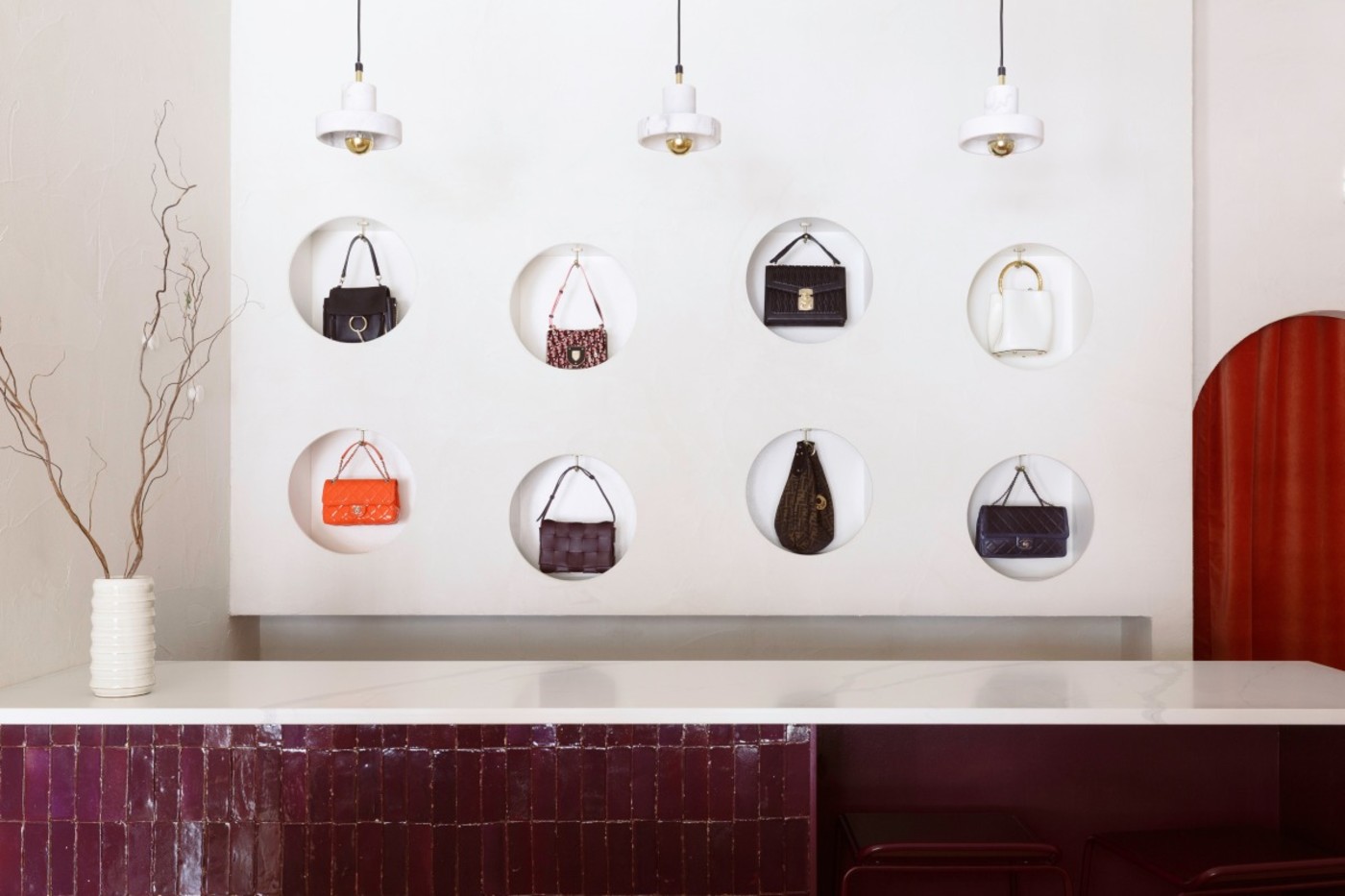 handbags hanging on a wall in a retail space.