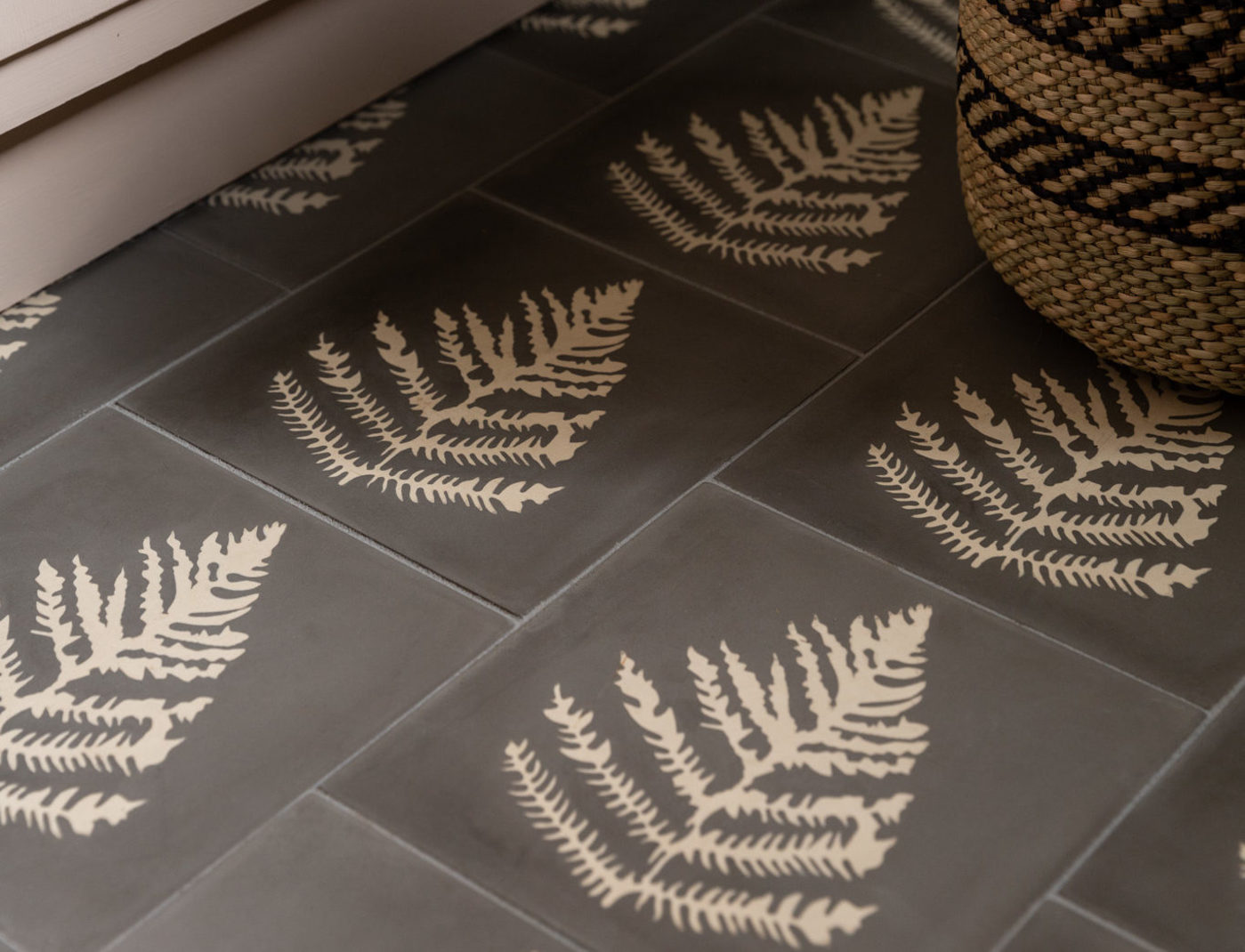 a grey tiled floor with fern leaf designs.