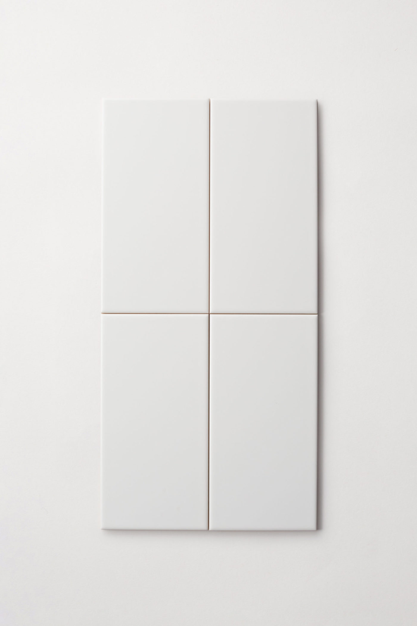 four rectangular white tiles on a white surface.