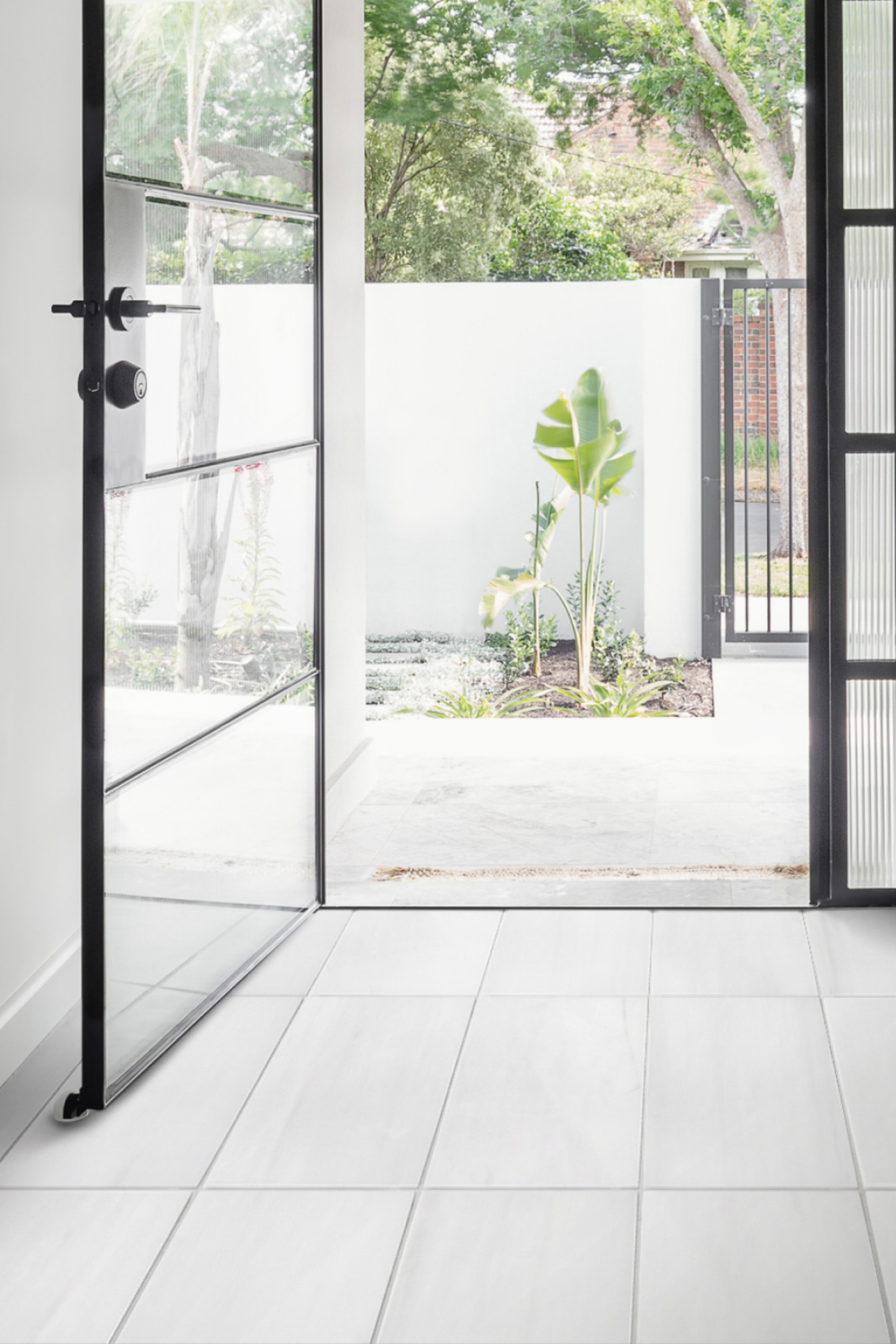 a doorway with a black door and white tile.