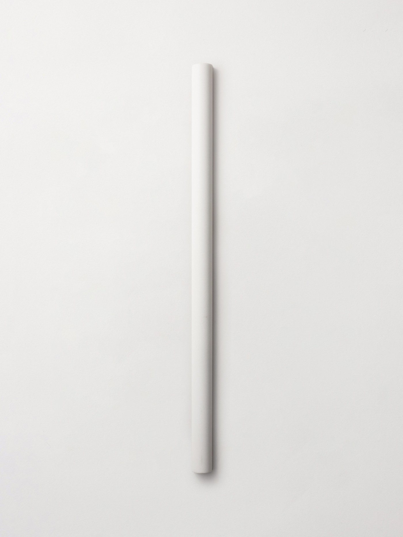 A single  long linear, curved convex stone tile in color Thassos, from clÃ©âs Lapidary collection featuring 3d sculpted (fluted and rounded) shapes.