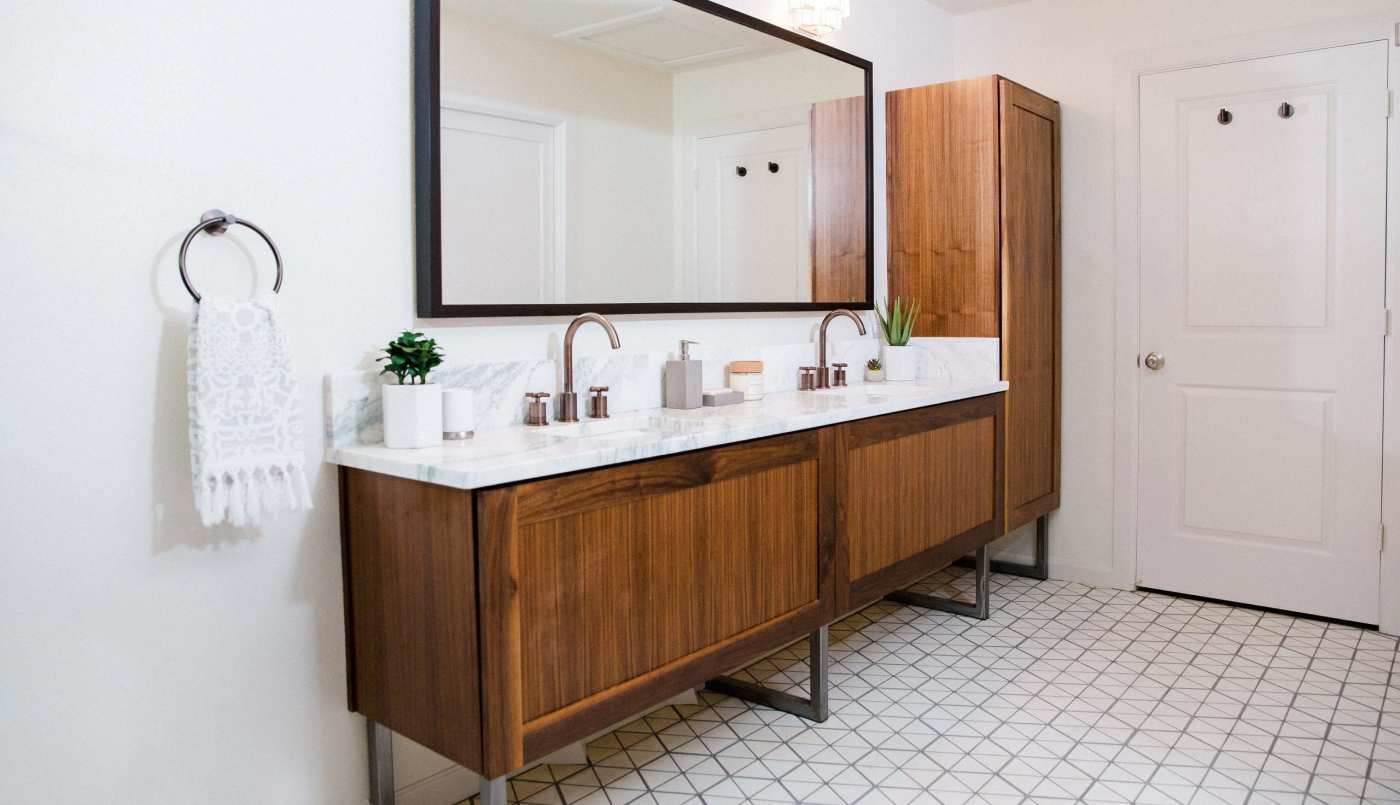 a bathroom with wooden cabinets and a mirror.