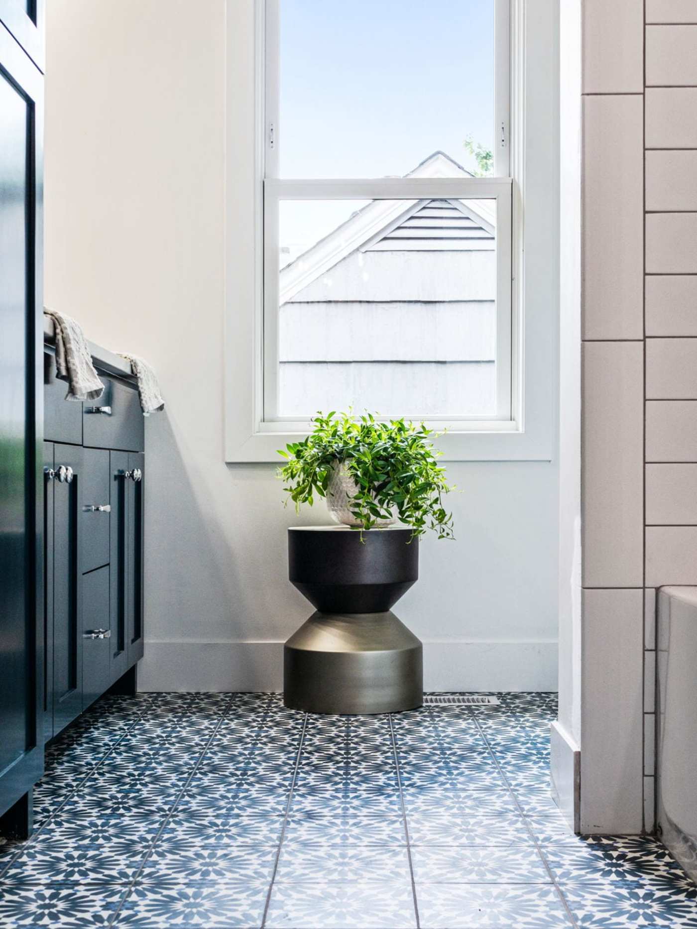 a bathroom with blue and white tiled floors and a potted plant.