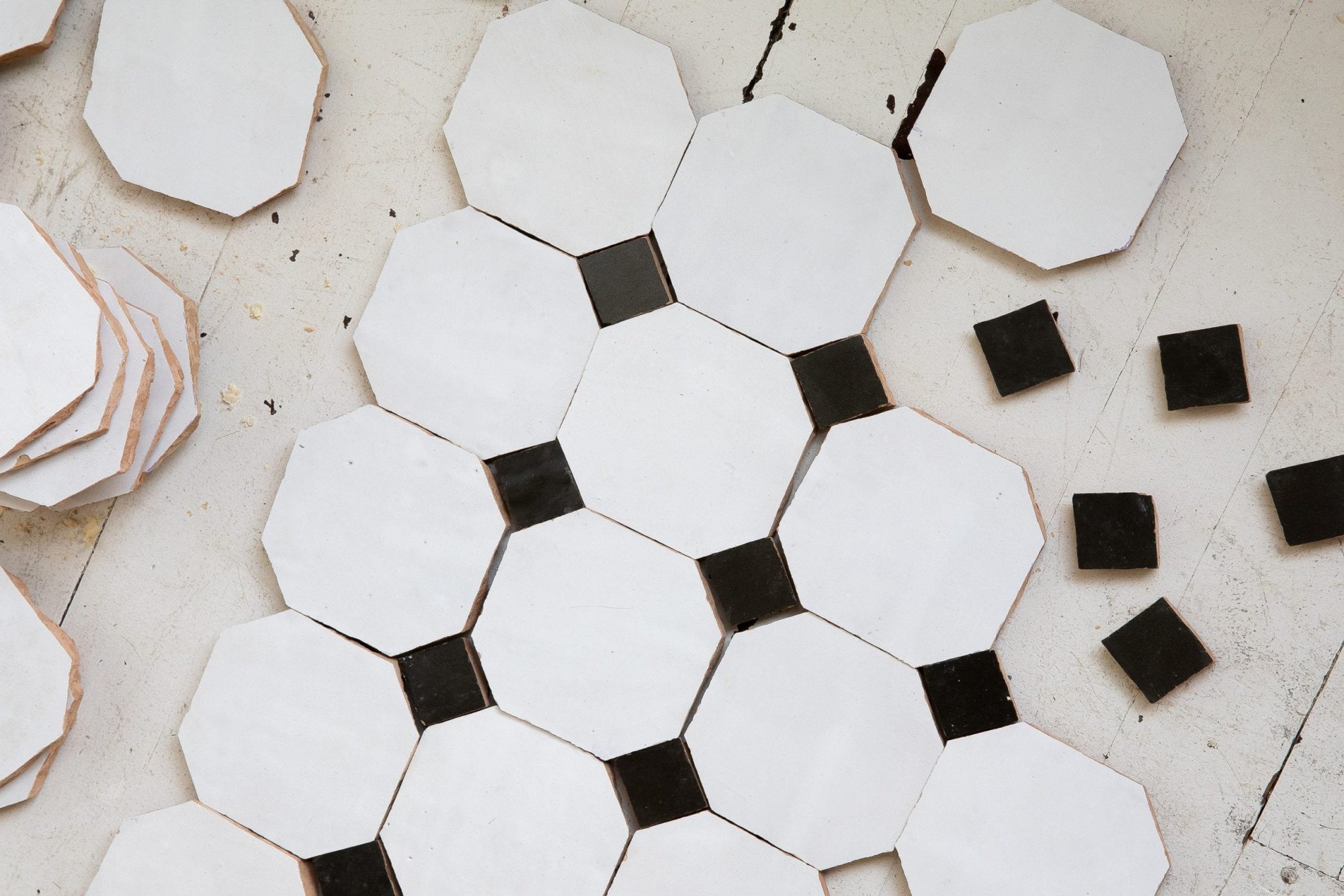 black and white tiles laid out on a floor.