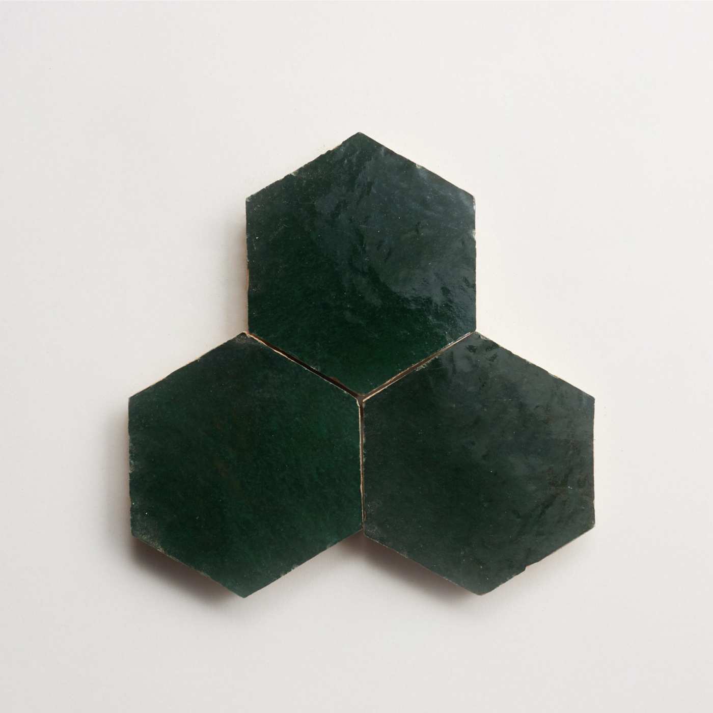 three green hexagon tiles on a white surface.