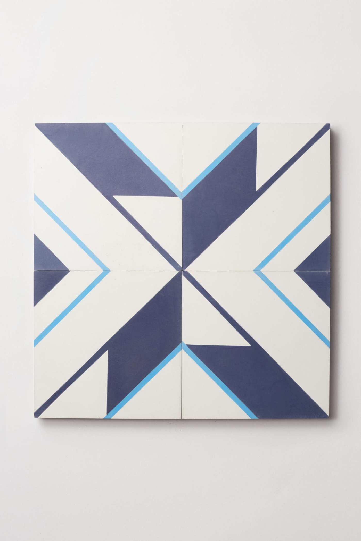 a quartet of blue and white tiles on a white surface.