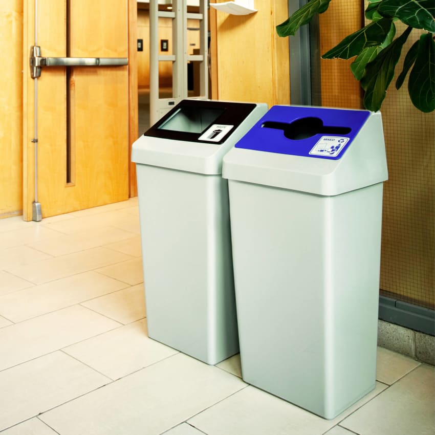 double waste and recycling station with grey body and colored restrictive opening lids in a college hallway