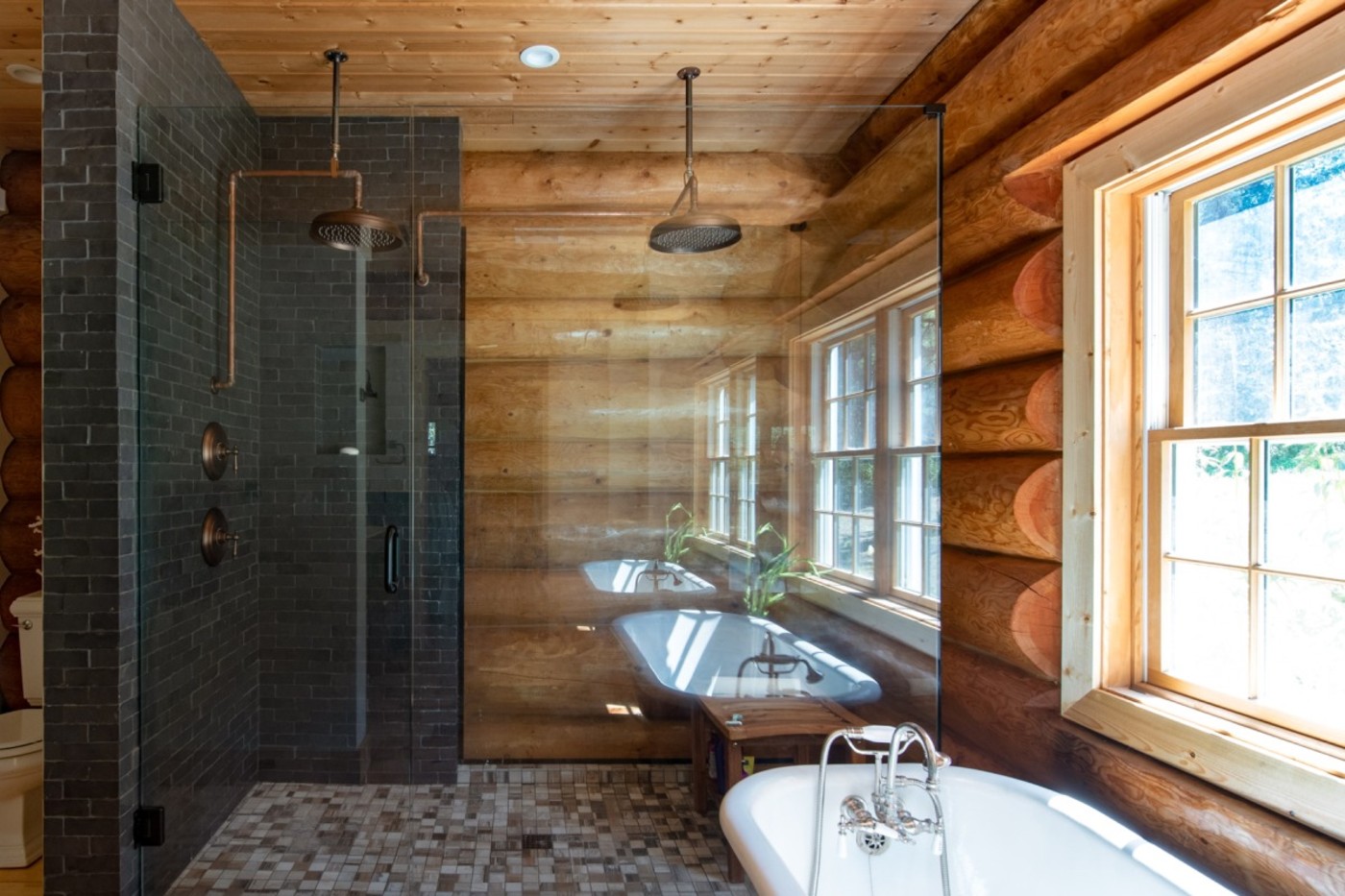 a bathroom in a log cabin with a glass shower.