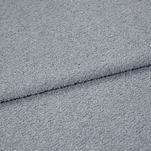 Light-gray bouclÃ© fabric folded once, showing pebbled loop texture; close-up macro view under soft, even lighting on a neutral surface, emphasizing tactile, cozy upholstery material.