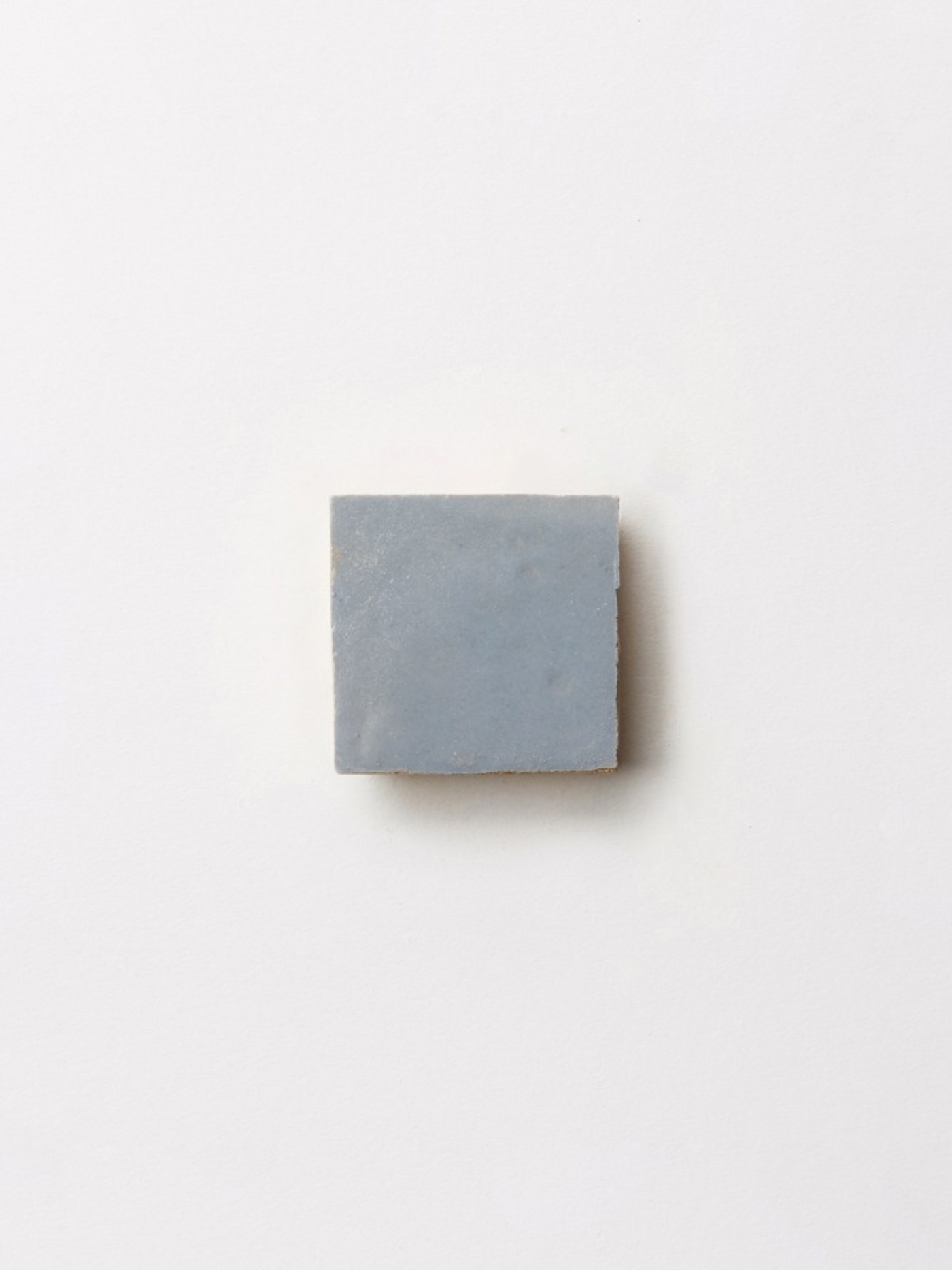 a blue square tile on a white background.