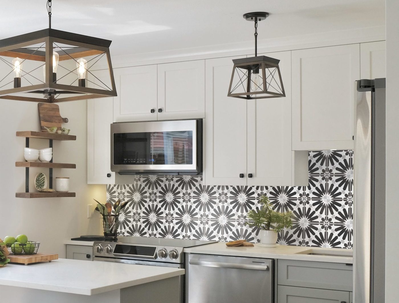 a kitchen with a black and white tile backsplash.