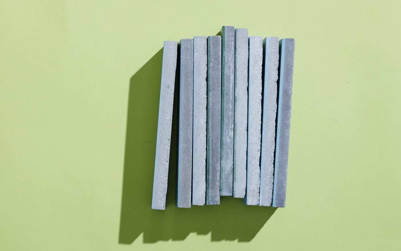 a stack of cement tiles on a green surface.