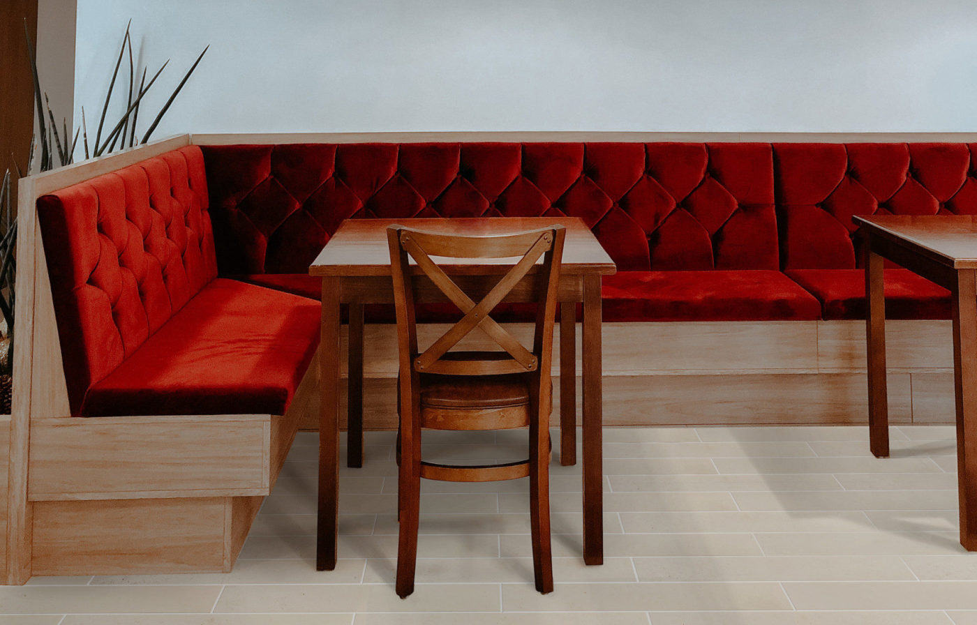 a wooden table with a chair and a red upholstered bench.