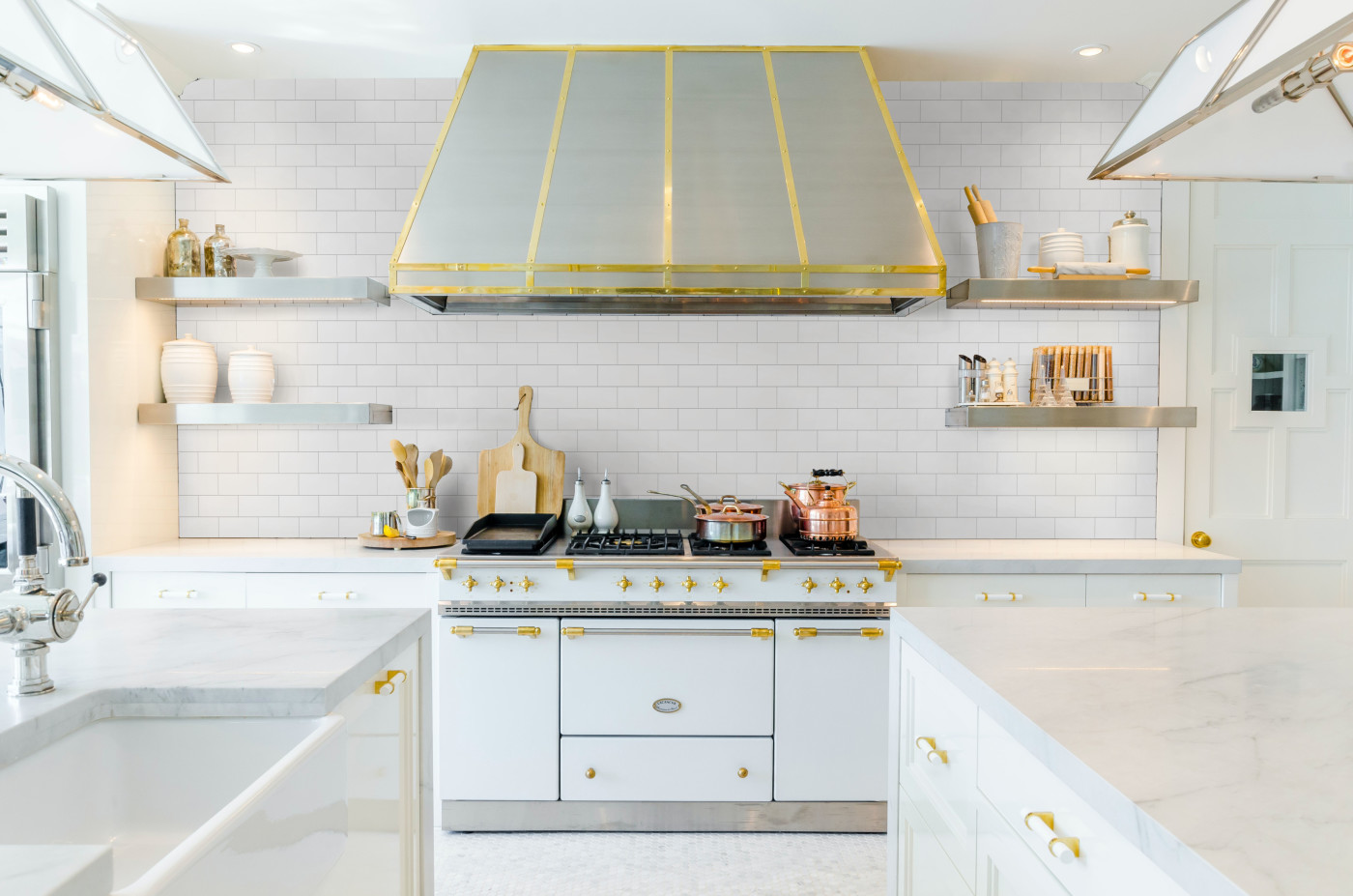 a white kitchen with a gold hood.