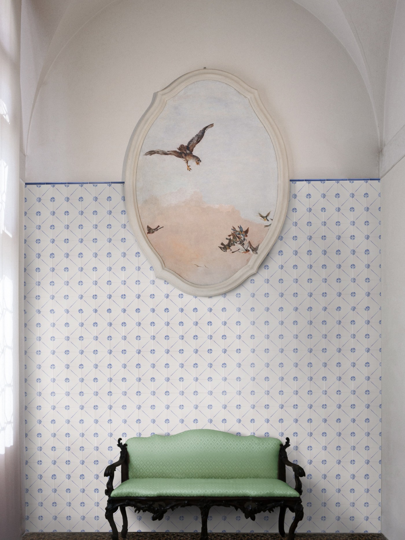 a green bench in a room with a painting on a blue and white tile wall.