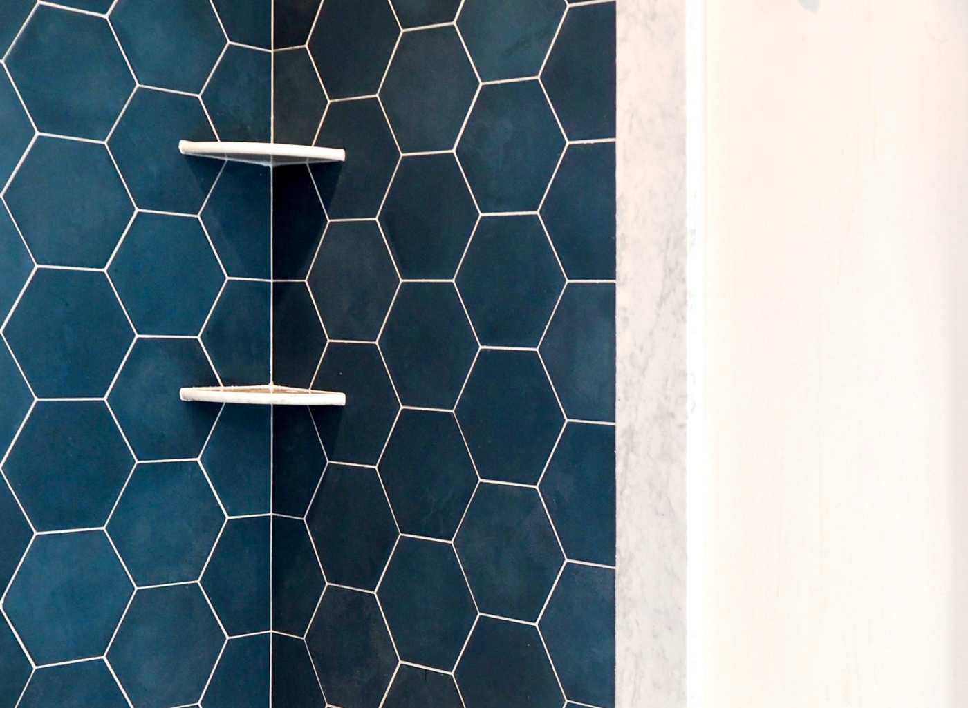 a bathroom with a blue hexagon tiled shower.