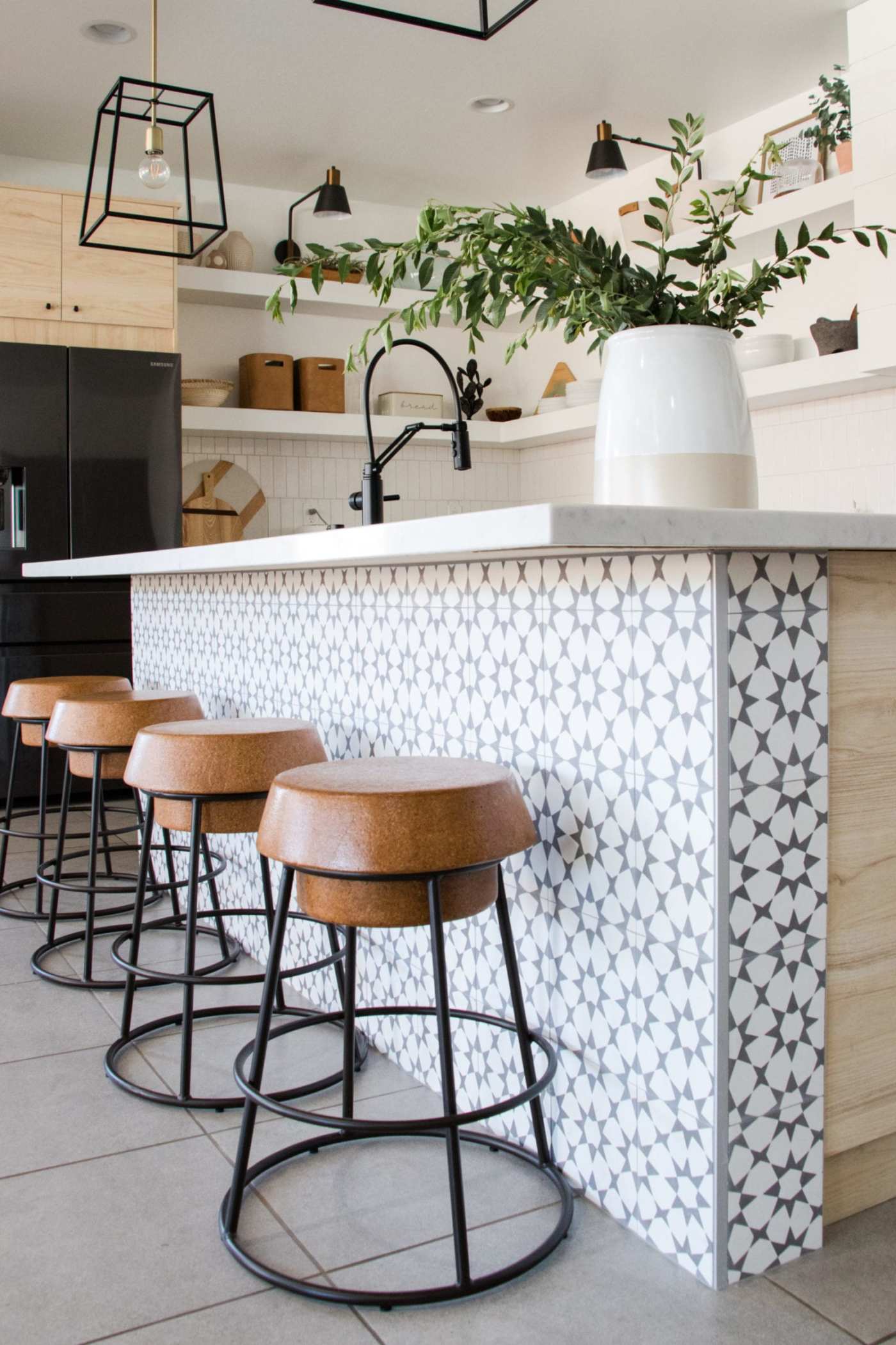 a kitchen with black and white tile and stools.