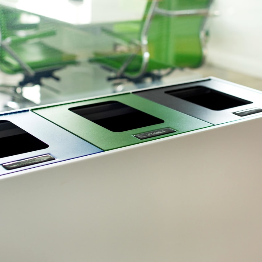 white powder coated steel recycling and waste container with color coded lids and lid labels in a modern office space