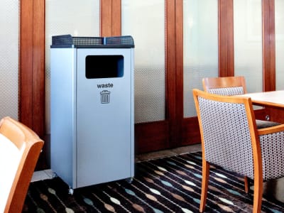 single waste collection bin made from restaurants that includes a tray holder on top sitting in a hotel restaurant