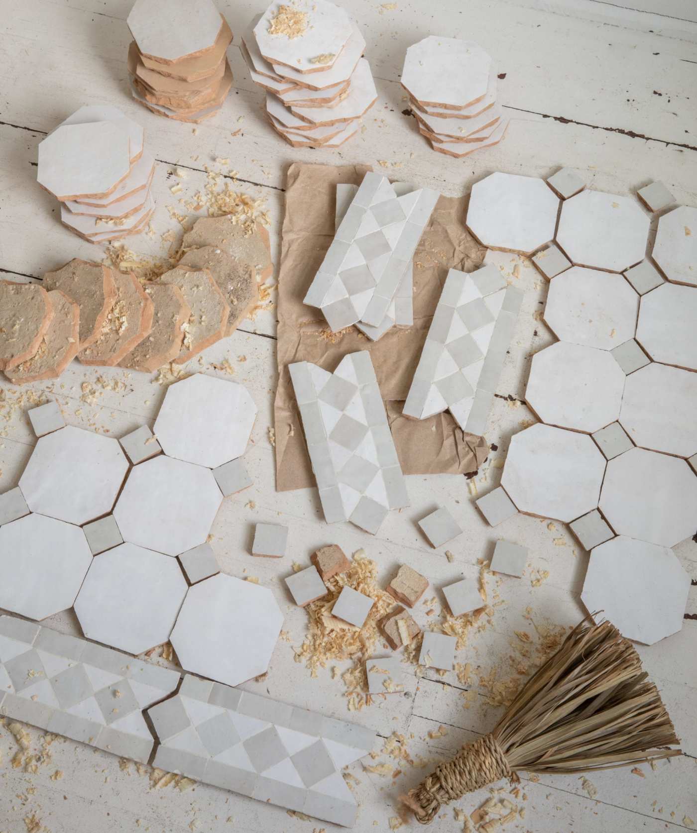 a table with a variety of tiles and a broom.