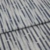 Gray woven fabric with textured weave and vertical navy elongated-dash pattern, folded across center; close-up on a flat surface showing fibers and subtle shadowing in soft, even lighting.