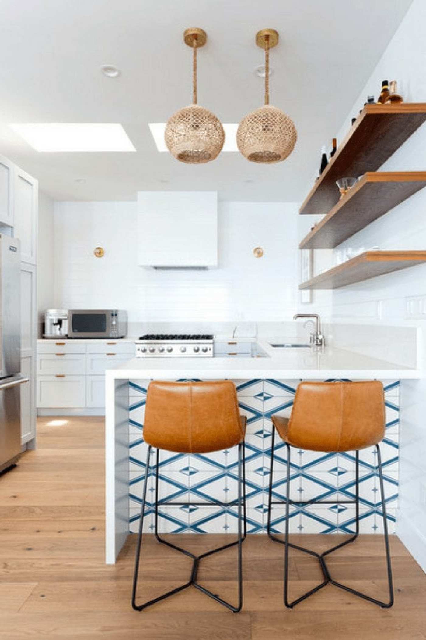 a white kitchen with a wooden island and stools.