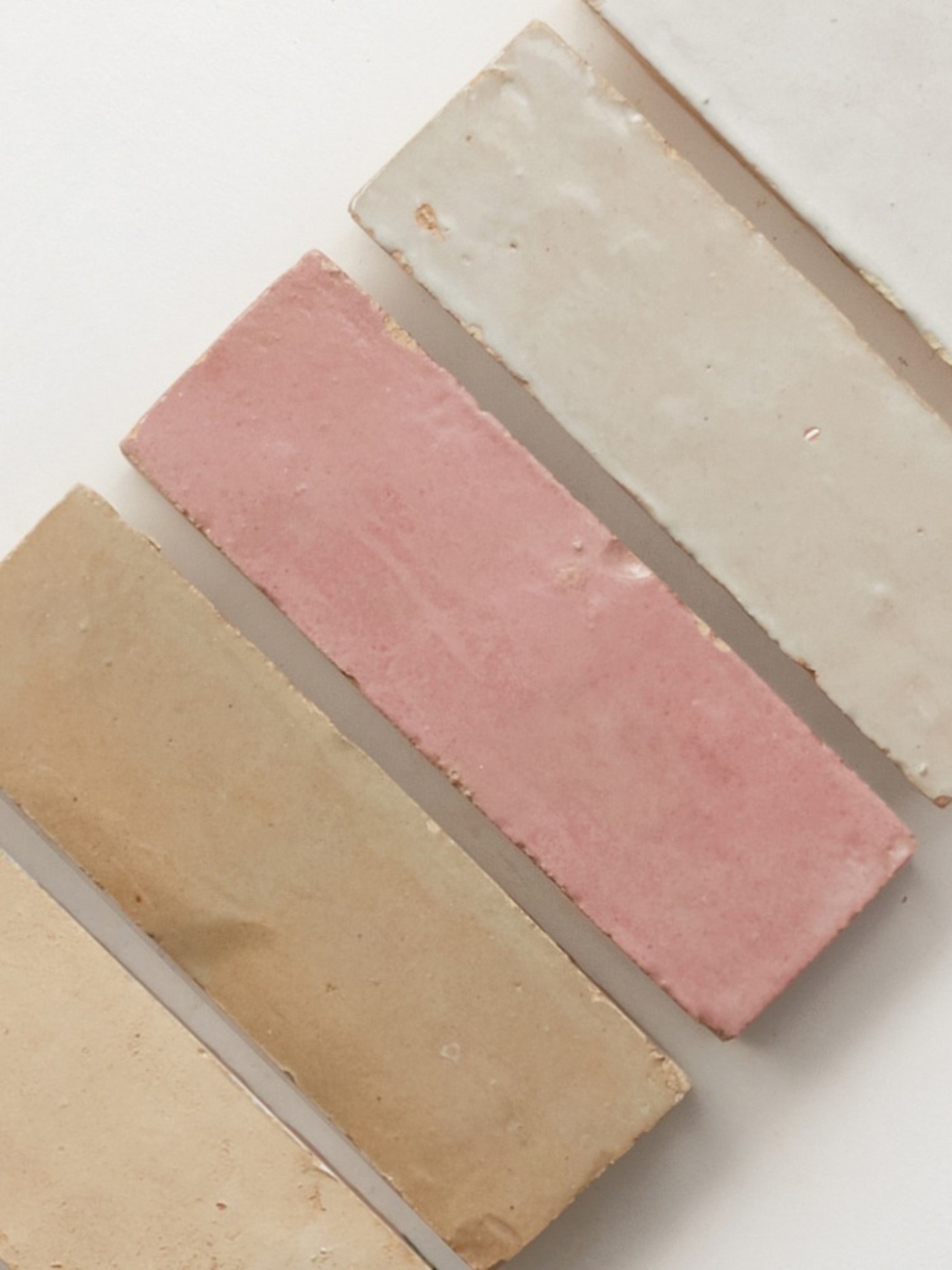 a row of pink, brown and white tiles on a white surface.