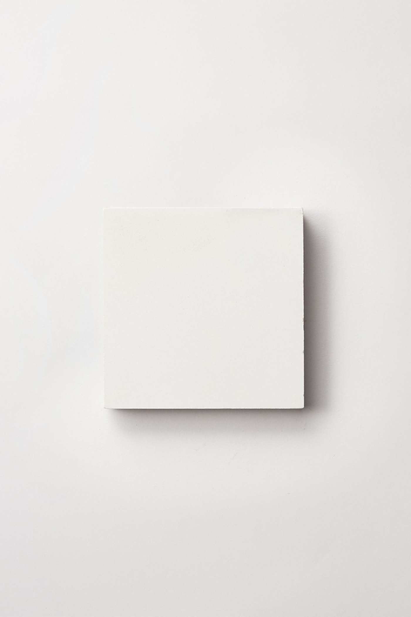 a square white tile on a white surface.