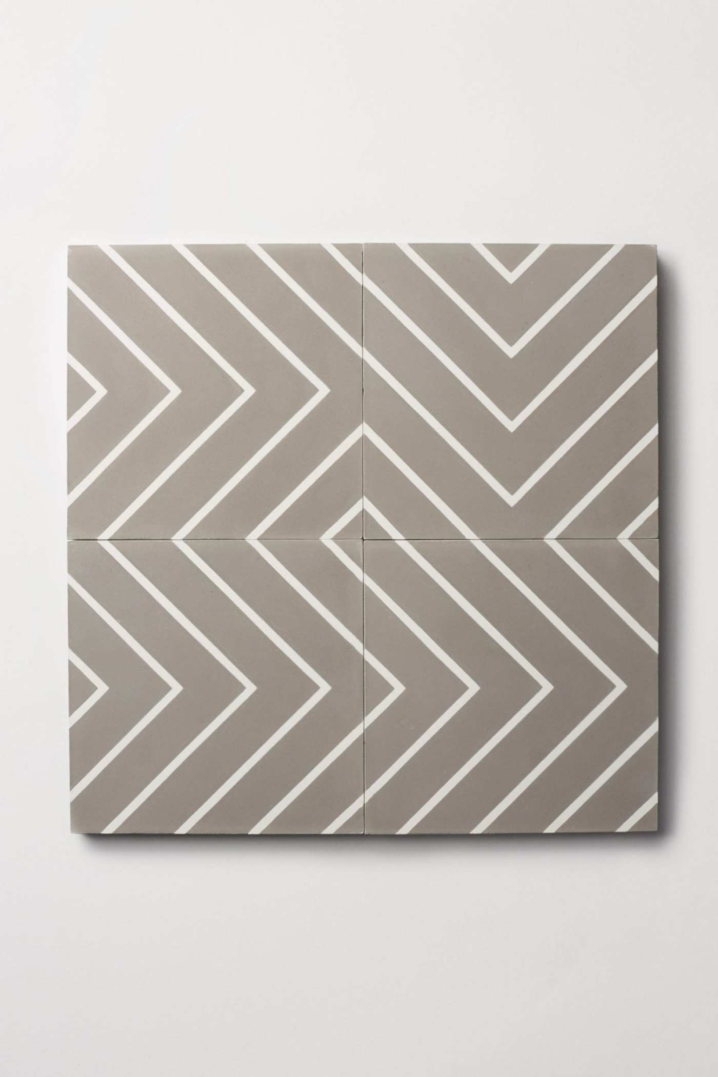 four grey and white tiles forming chevron patterns on a white surface.