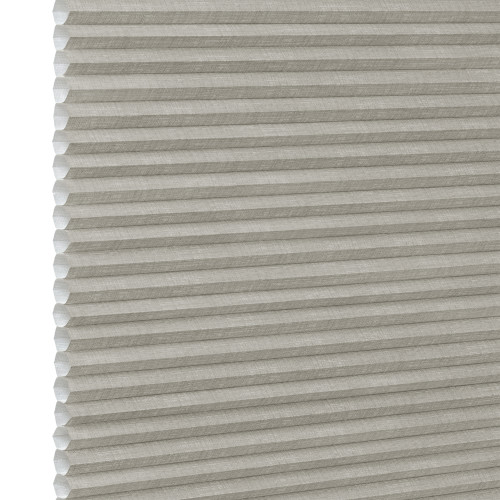 Honeycomb cellular fabric blind with horizontal pleats and textured beige finish, fully lowered and closed, diffusing soft light; set against a neutral, evenly lit wall with narrow white margin left.