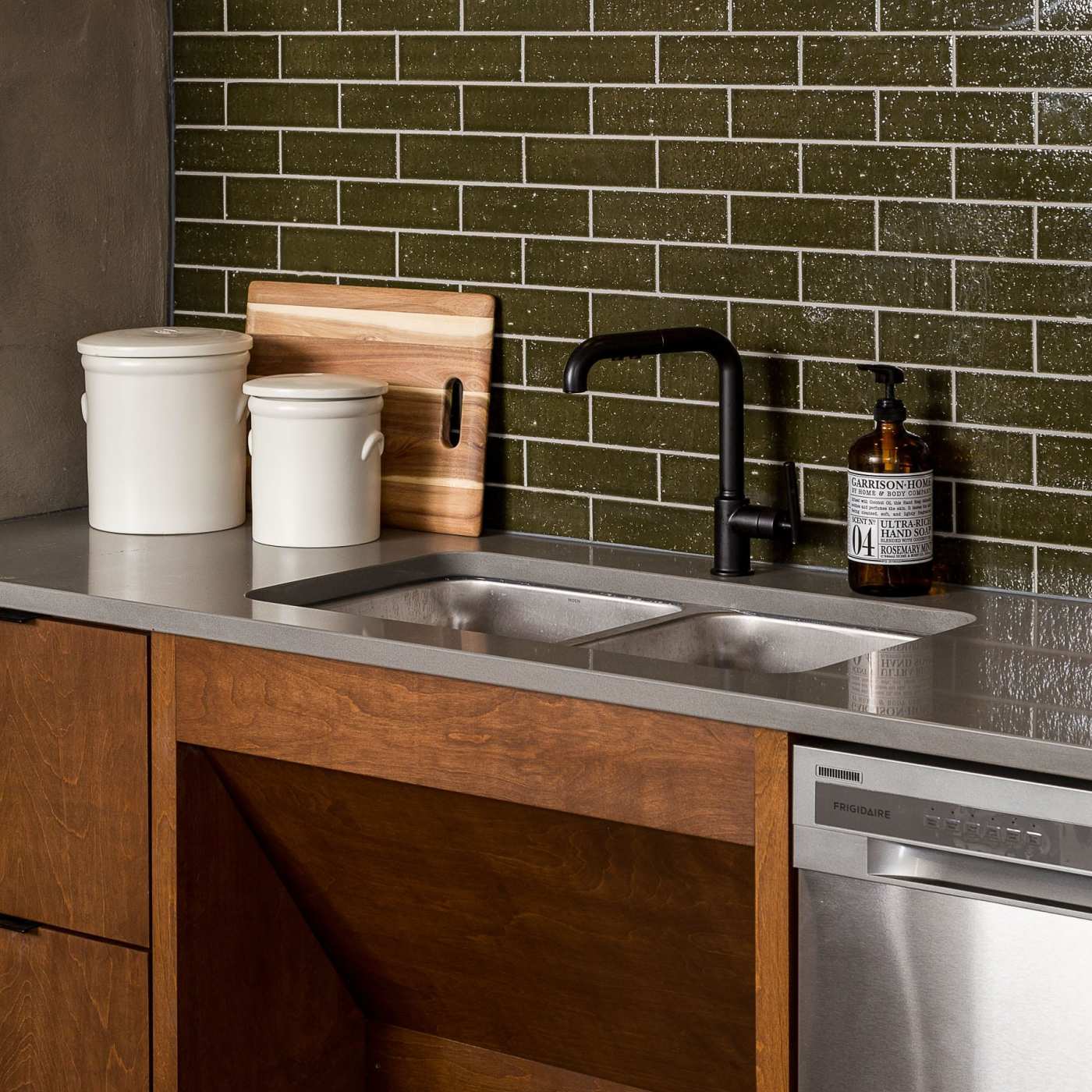 a kitchen with a green tile backsplash.