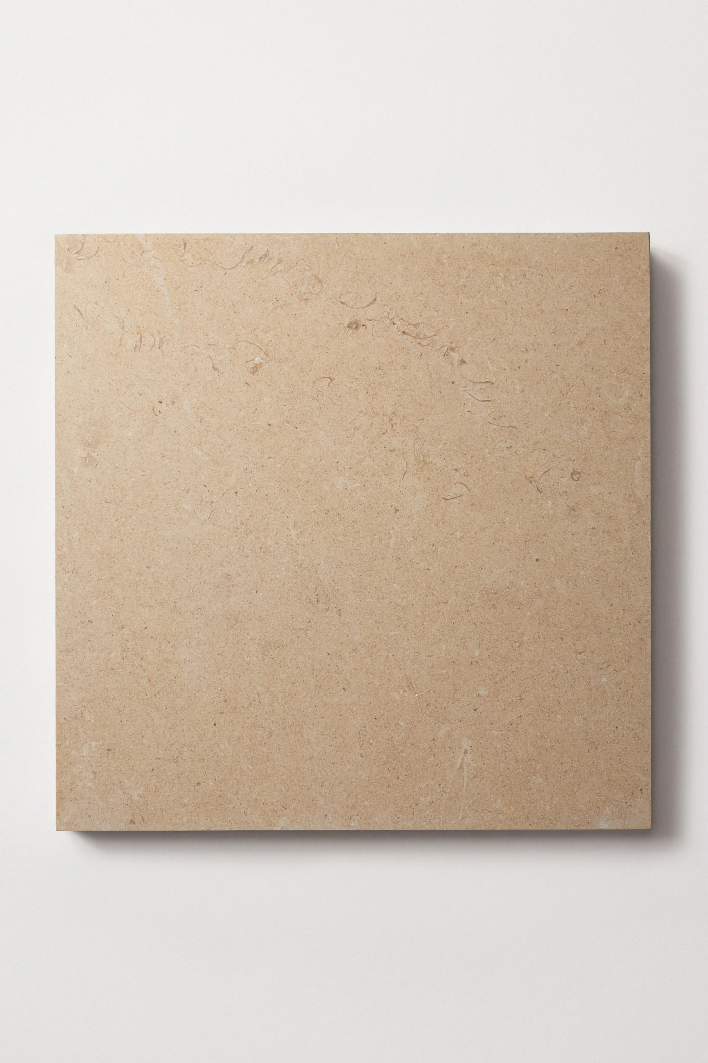 A square tan colored limestone tile centered on a white background.