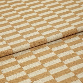 Woven beige-and-cream checkered fabric folded to create an overlapping edge, close-up studio-lit view highlighting the textured weave and repetitive rectangular pattern.