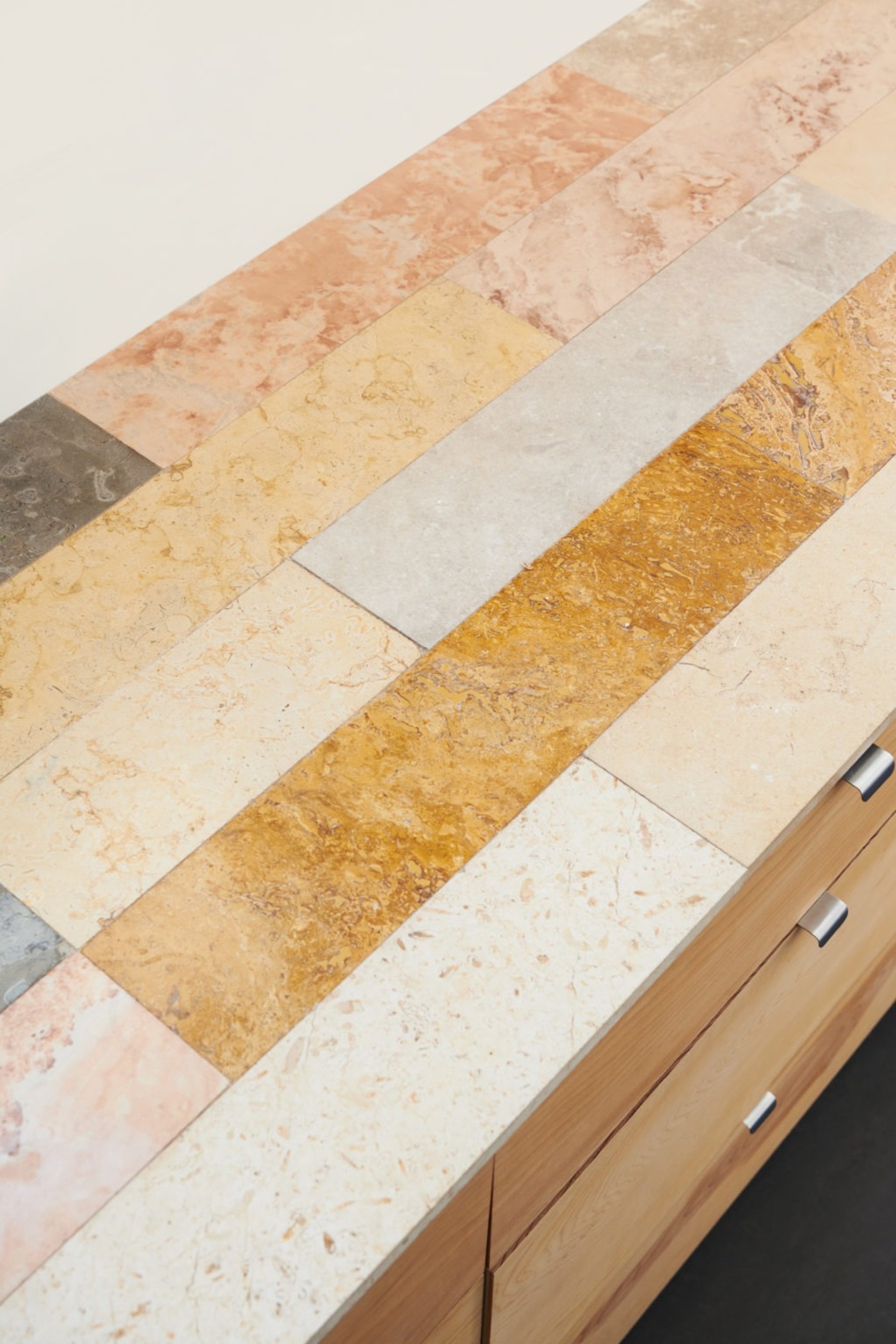 a kitchen counter with a variety of colored tiles.