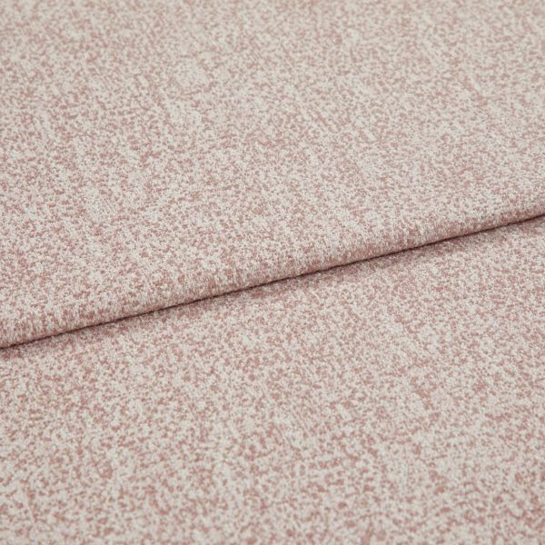 Pink-speckled upholstery fabric with a fine bouclé texture, folded and layered along a horizontal crease; lying flat in a close-up view with soft, even lighting.