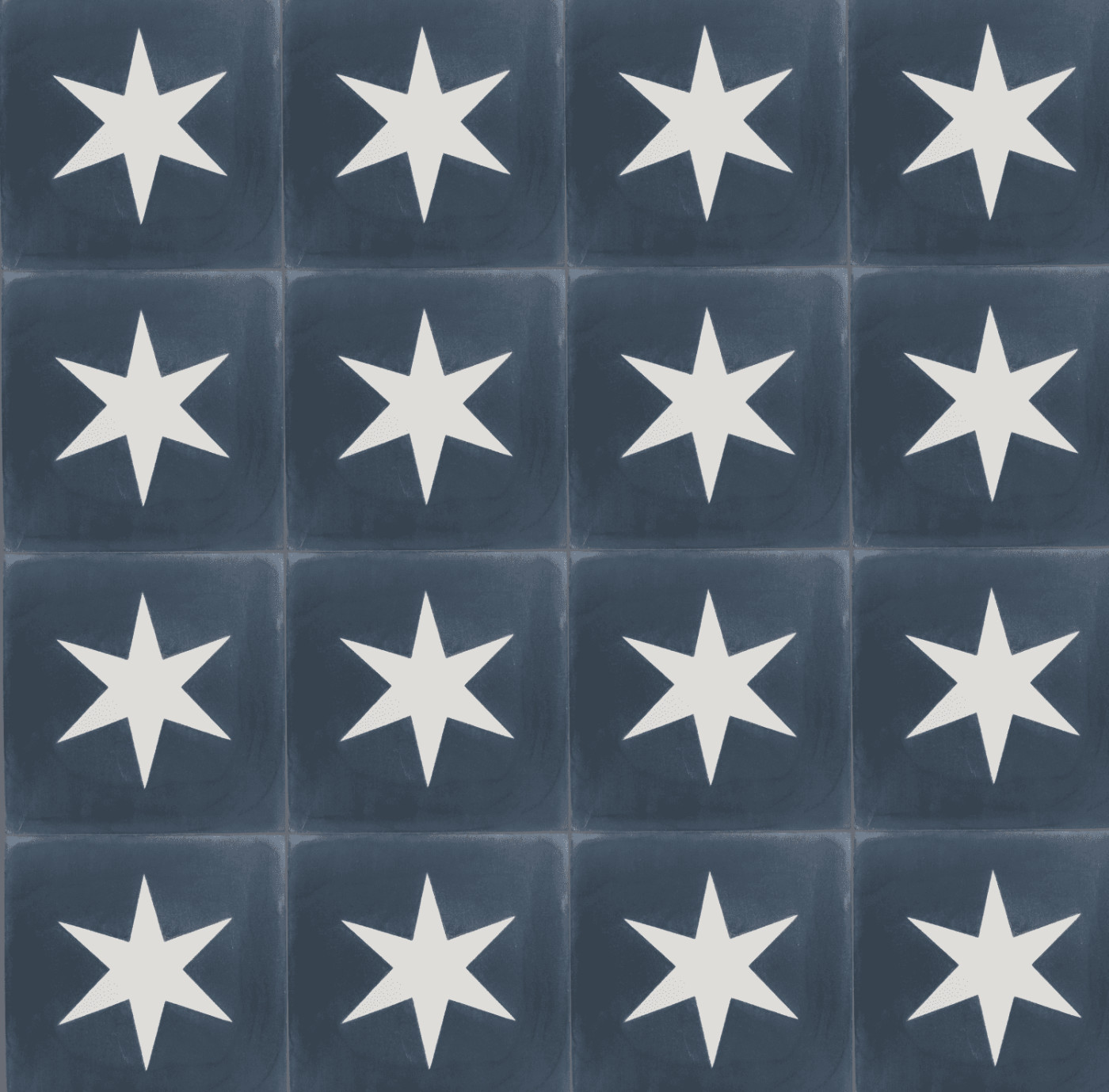 a surface of blue tiles with white star designs on them.